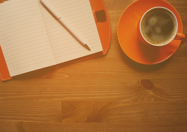 zápisník a šálek kávy na stolku